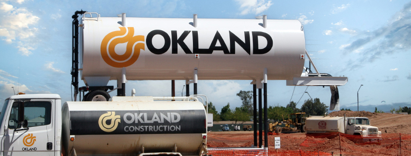 Okland Construction vinyl graphics on a large water tank and truck tanker.
