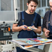 2 men at at print shop looking over color samples