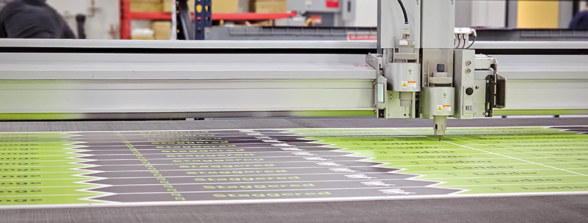 close-up of a zund cutter routing some printed signage.