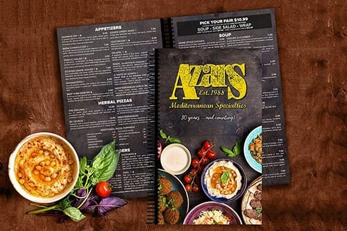 Printed restaurant menu beside a prepared dish.