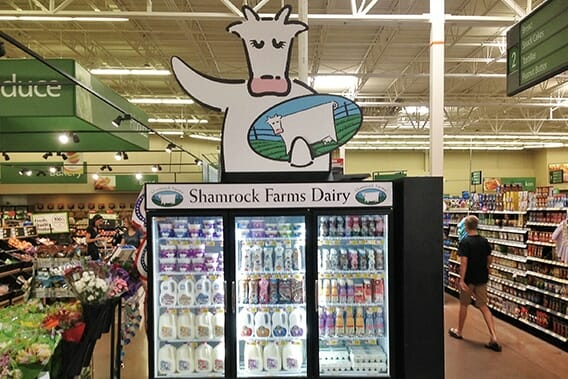 Printed store advertising for Shamrock Farm Dairy on top of a store cooler