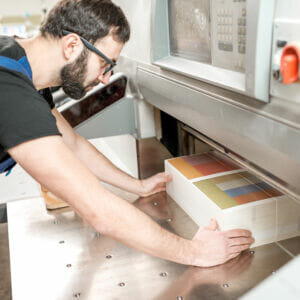 small format printing man trimming paper commercial printer