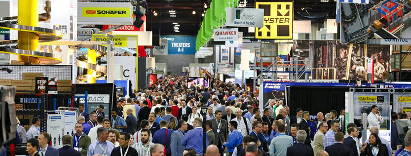 View of busy trade show with a large crowd.