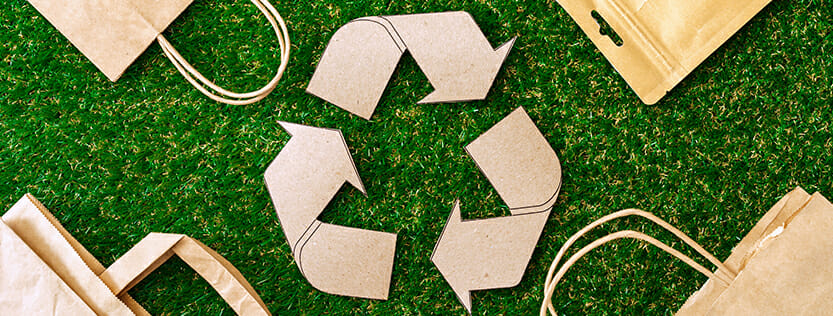 Recycle logo surrounded by different paper products.