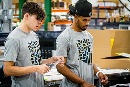 PRI_About-Page-Our-Team Two PRI Graphics & Signs employees working on a project.