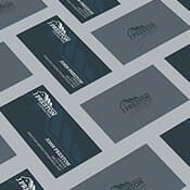 Business cards are displayed on a grey table showing the front and back of the cards.