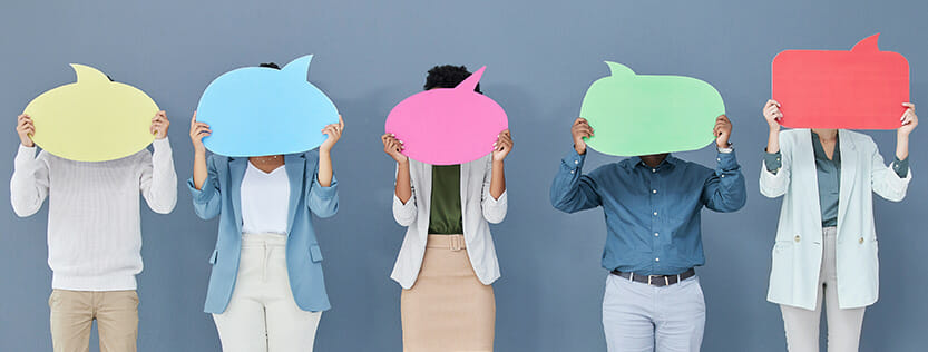 Various people standing side by side holding chat bubbles in front of their face.