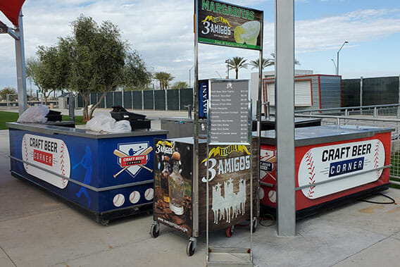 Mobile vending counters at ballpark wrapped with vinyl graphics.