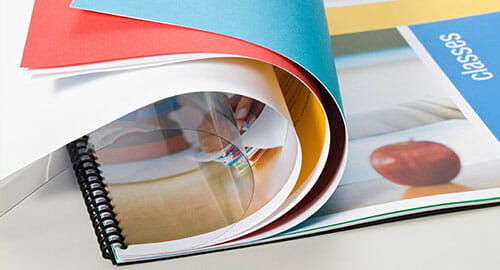 Spiral-bound presentation booklet with pages turned over.