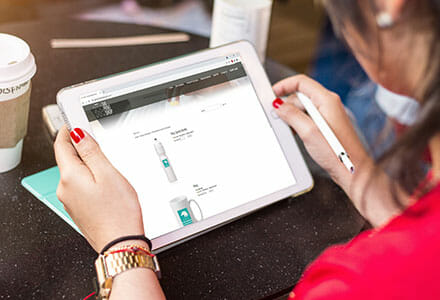 Woman looking at iPad tablet showcasing promotional products.