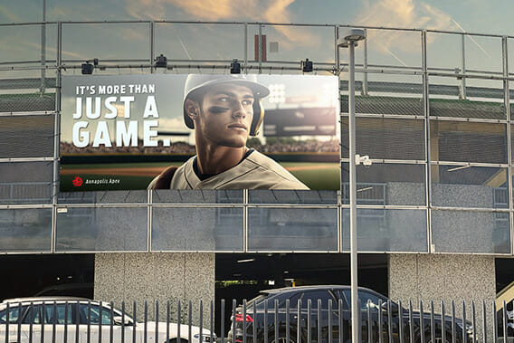 A stadium billboard showing a baseball player with the caption "It's more than just a game."